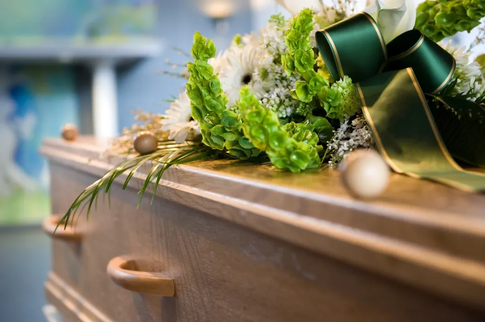 Cercueil en bois avec bouquet de fleur sur le dessus